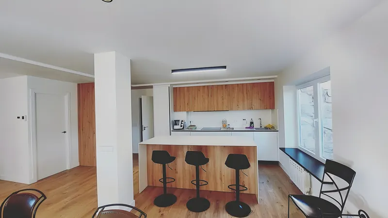 Cocina abierta al salón con taburetes negros