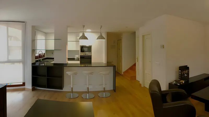 El mismo salón con la cocina abierta y la península